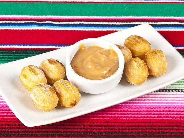 Porção com 8 mini churros recheados e acompanhados doce de leite